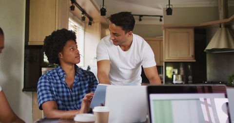 Two Diverse Men Collaborating on Laptop in Kitchen