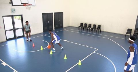 Athletes Dribbling Through Cones During Basketball Conditioning Training