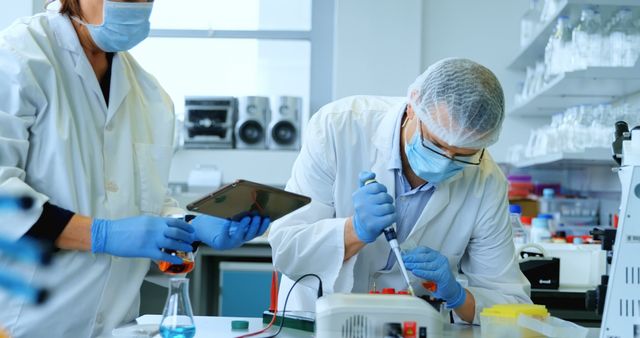 Caucasian scientists conduct research in a lab. They are focused on an experiment, surrounded by advanced scientific equipment.