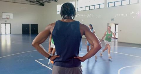 Athletic coach leading basketball training drill on indoor court promoting teamwork skills