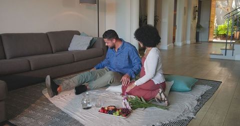 Couple Sharing Snacks and Flowers in Cozy Living Room
