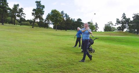 Senior couple enjoying leisurely golf game on sunny day