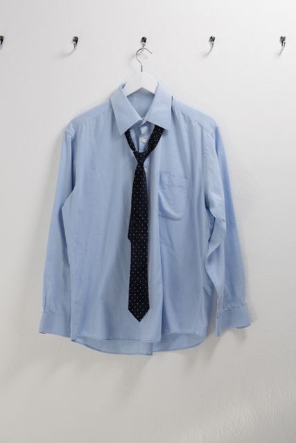 Shirt with tie hanging on hook against wall