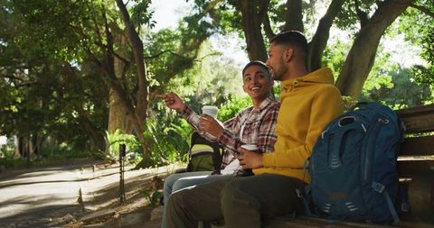 Two Friends Enjoying Park Break with Coffee