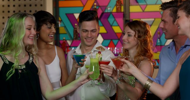 Group of diverse friends raising colorful cocktails in cheerful toast at a lively bar. Suitable for illustrations related to nightlife, celebrations, social gatherings, and parties.