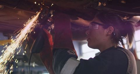 Female Mechanic Operating Angle Grinder With Precision in Workshop