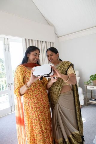 Mother and daughter exploring virtual reality in modern living room