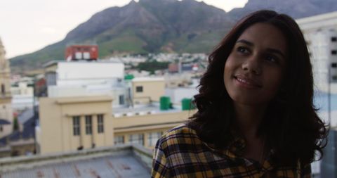 Smiling Biracial Woman Enjoying Rooftop Party with Scenic Cityscape - Download Free Stock Images Pikwizard.com