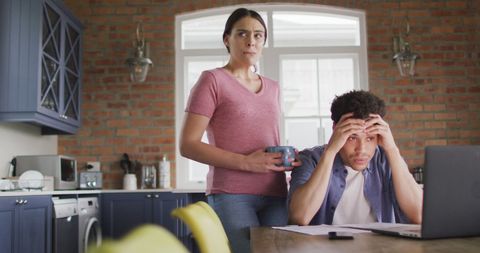 Worried couple working on finances at kitchen table