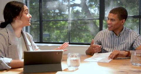 Diverse Team Collaborating in Office with Tablet and Documents