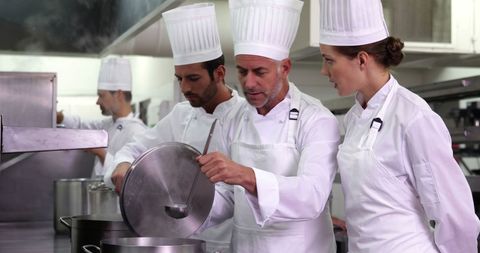 Chefs Collaborating on Recipe in Professional Kitchen