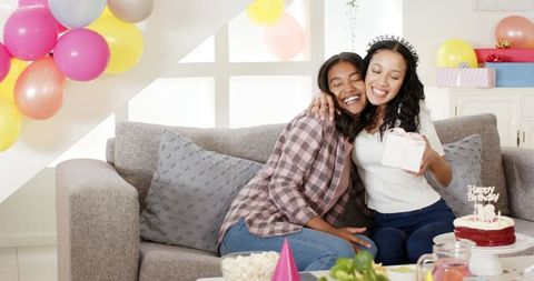 Friends Celebrating Birthday Exchanging Gifts on Couch