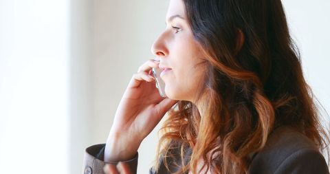 Businesswoman making phone call in office setting