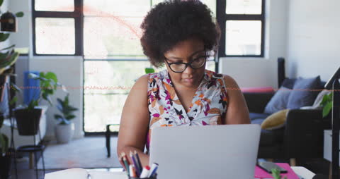 Focused Woman Analyzing Data on Laptop in Modern Office