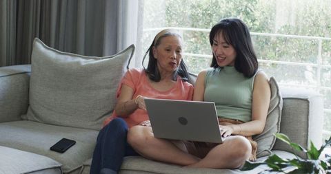 Intergenerational Bonding as Grandmother and Granddaughter Enjoy Laptop Time