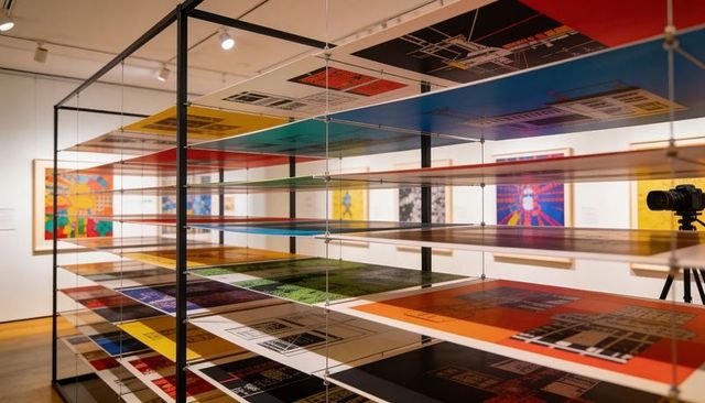 Multilevel print rack installation showing colorful geometric screenprints in gallery