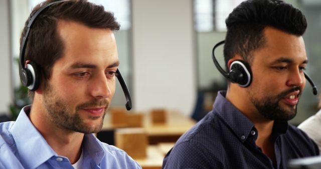 Customer service representatives wearing headsets, working in a call center, looking focused and professional. Ideal for illustrating teamwork in a customer service environment, professional communication settings, or business support services.