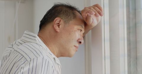 Thoughtful Elderly Man Gazing Through Window in Serene Homescape
