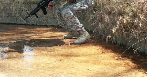 Soldier Navigating Shallow Water Challenge in Military Exercise