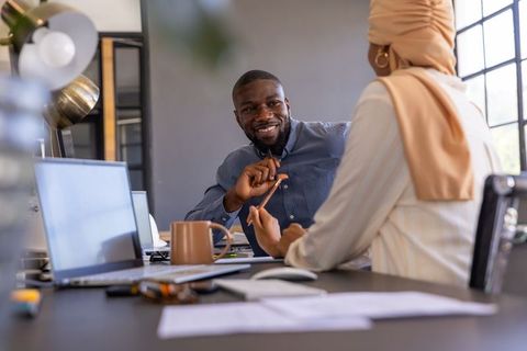 Diverse coworkers discussing at office desk