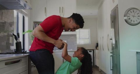 Parent and child sharing a joyful moment in modern kitchen