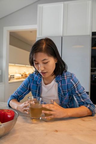 Woman Holding Beverages in Authentic Kitchen Setting