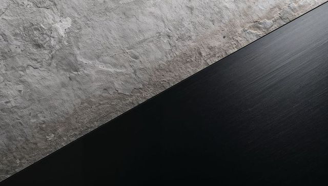 Diagonal contrast showing weathered plaster meeting dark brushed metal panel
