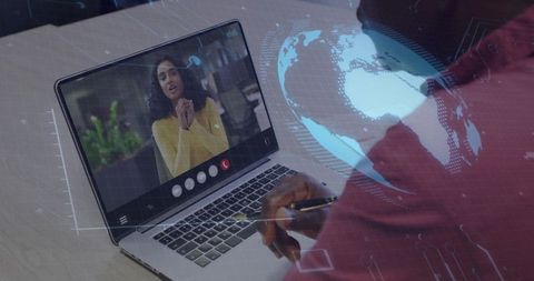 Man holding pen joining global virtual meeting on laptop with woman presenting