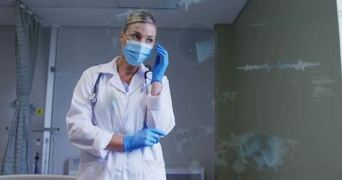 Female doctor adjusting mask in hospital bay with AR medical overlays and stethoscope