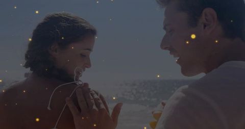 Romantic couple sharing sunset moment on beach, golden bokeh glow, ocean romance