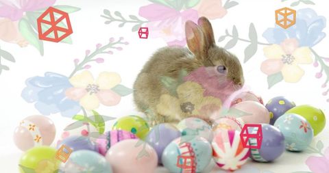 Pastel easter bunny snuggling among decorated eggs with watercolor floral overlays