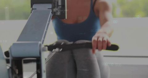 Woman in Sportswear Exercising on Rowing Machine in Gym