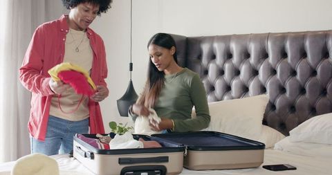 Couple Collaborating on Travel Packing in Cozy Bedroom