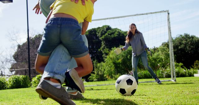 A boy plays soccer with his mother, enjoying active outdoor family bonding. - Download Free Stock Photos Pikwizard.com