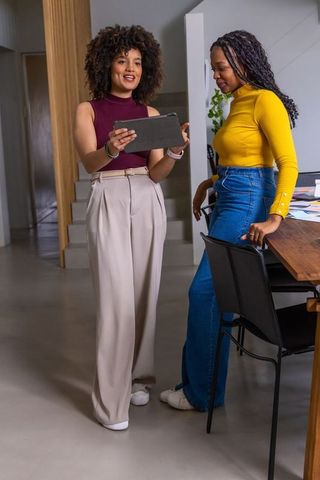 African american coworkers reviewing tablet and collaborating in modern office workspace