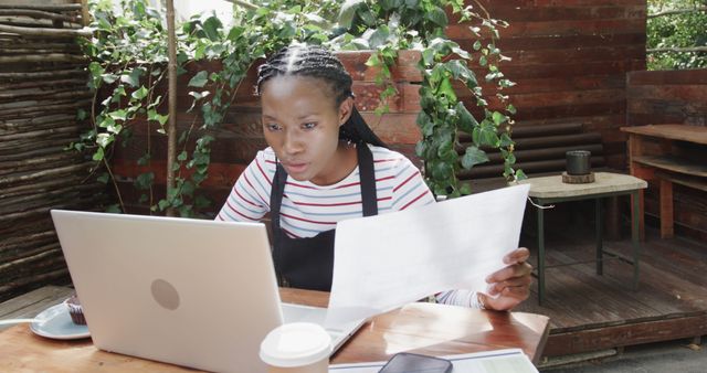 Focused Young Woman Analyzing Documents in Garden Workspace - Download Free Stock Images Pikwizard.com