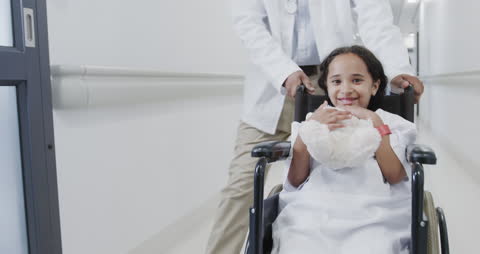 Smiling Young Patient in Wheelchair with Medical Practitioner