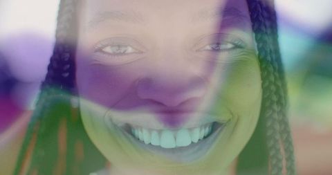 Woman with braided hair illuminated by colorful light patterns