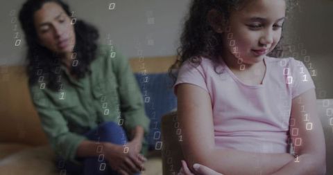Child sitting with arms crossed on couch while caregiver watching with digital binary overlay
