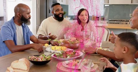Multigenerational family sharing dinner at modern open-plan kitchen table, smiling