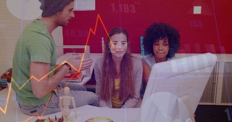 Creative team collaborating around desktop with data analytics overlay and brainstorming
