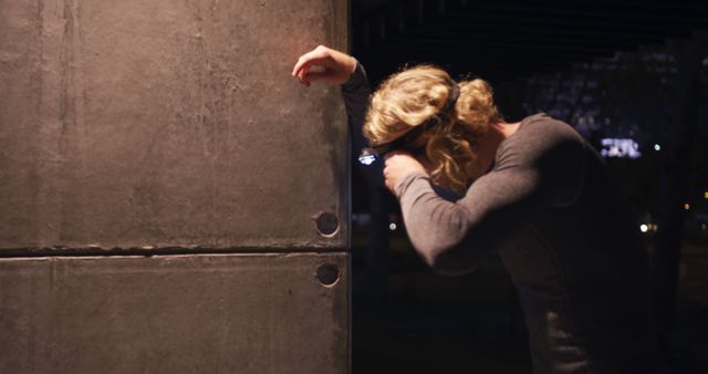 Distressed Person Leaning Against Concrete Wall in Dark Urban Setting - Download Free Stock Images Pikwizard.com