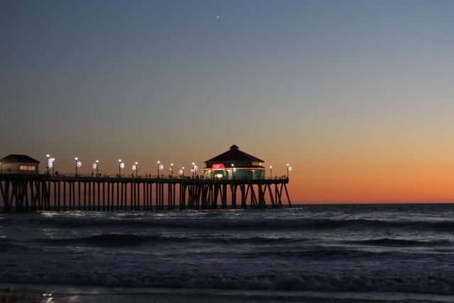 Sunset Over Huntington Beach Pier with Illuminated Lights and Calm Ocean - Download Free Stock Images Pikwizard.com