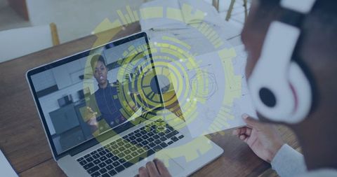 Architect collaborating online using laptop and headphones