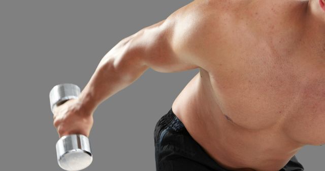 A Caucasian young man is lifting a dumbbell, focusing on his bicep workout, with copy space - Download Free Stock Photos Pikwizard.com