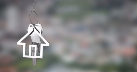 House Keychain Symbolizing Home Ownership in Urban Environment