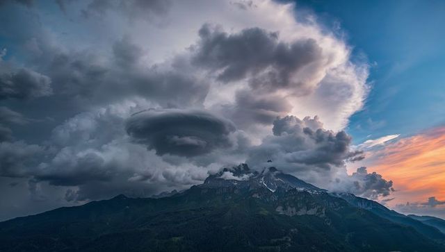 Majestic Cumulonimbus Cloud Over Mountain Ridge at Sunset