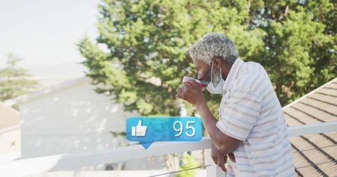 Senior man relaxing on balcony with social media interaction