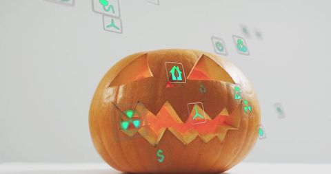 Glowing jack-o'-lantern projecting futuristic green holographic icons on white tabletop