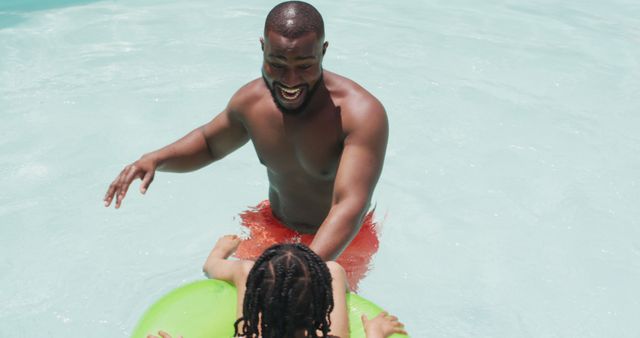 Smiling Father Playfully Pushing Child on Inflatable in Swimming Pool - Download Free Stock Images Pikwizard.com